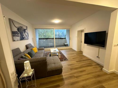 a living room with a couch and a flat screen tv at Appartamento "Rio Nero" in Ora/Auer