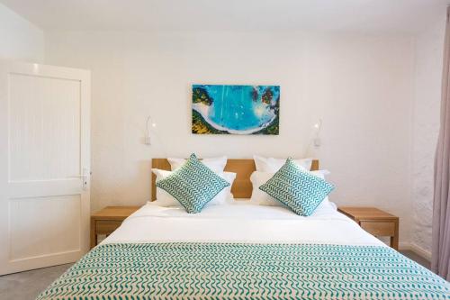 a bedroom with a bed with blue and white pillows at Quaint Beach Villa in a fishing village in Grand Gaube