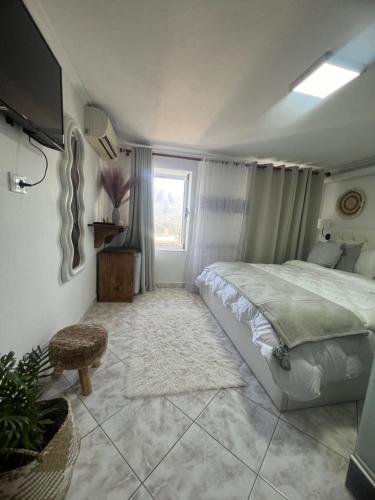 Un dormitorio con una cama grande y una ventana en Himalayas, en Gjirokastra