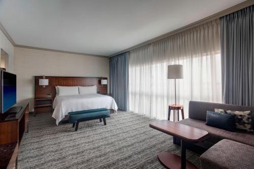 um quarto de hotel com uma cama e um sofá em Houston Airport Marriott at George Bush Intercontinental em Houston