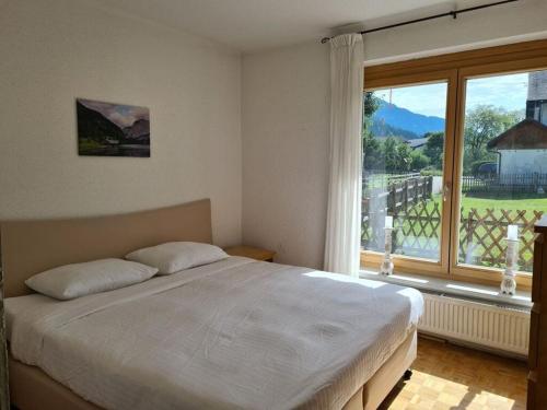 een slaapkamer met een bed en een groot raam bij Daffodil Modern Retreat in Bad Mitterndorf
