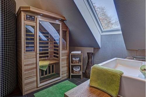 Baño en el ático con bañera y ventana en Apartment Adlerhorst - Schwalbenhof Farm, 