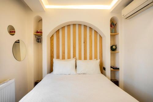 イスタンブールにあるエミール ホテルのベッドルーム(白い大型ベッド1台、木製ヘッドボード付)