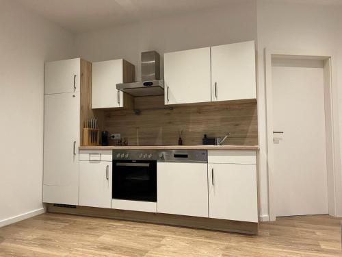 una cucina con armadietti bianchi e piano cottura di Murtal Appartment a Zeltweg