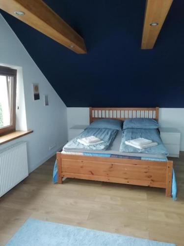 a bedroom with a wooden bed with a blue wall at Mrągowo Pokoje Apartament in Mrągowo