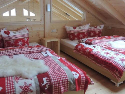 two beds in a room in a log cabin at Hüttenzauber 1 Modern retreat in Annaberg im Lammertal