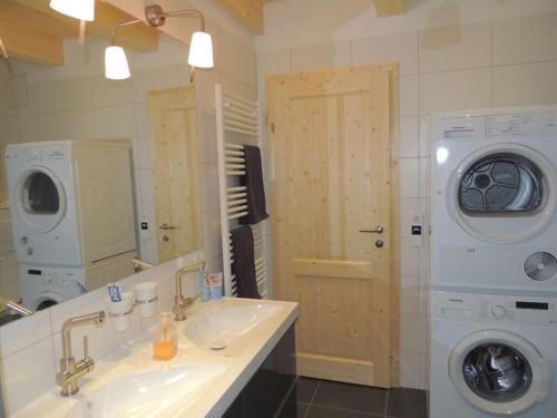 a bathroom with a sink and a washing machine at Hüttenzauber 1 Modern retreat in Annaberg im Lammertal