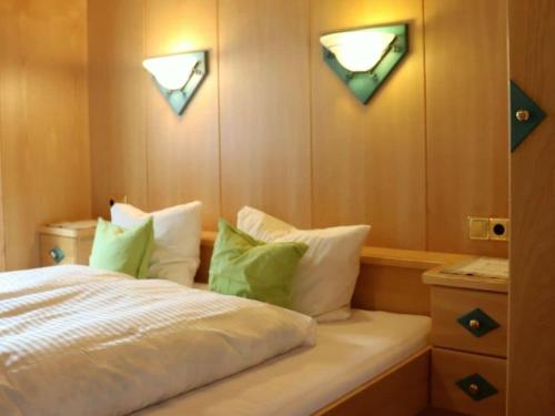 a bedroom with a bed with green and white pillows at Holiday apartment Bergstille in Längenfeld