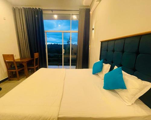 una camera da letto con un grande letto con una grande finestra di Hanthana SK Paradise a Gampola