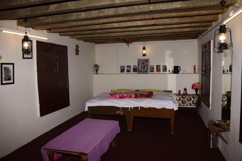 een slaapkamer met een bed en een paarse bank bij NotOnMap- Hidden Hamlet Gowari in Tisa
