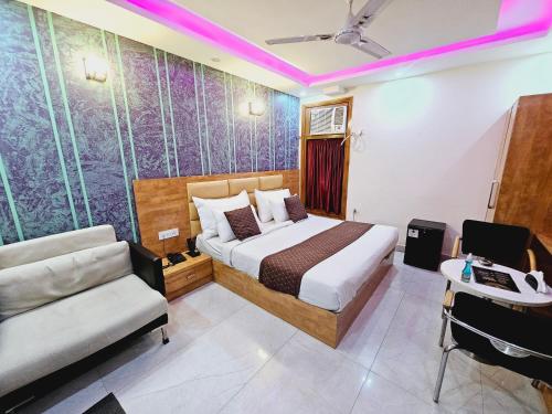 a bedroom with a bed and a couch and a desk at Hotel TU Casa (Stay near International Airport) in New Delhi