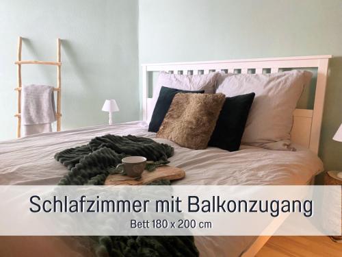 een slaapkamer met een wit bed en een houten hoofdeinde bij Fewo Herzgrün mit Balkon und Traumblick direkt an Wanderwegen und Sauna im Haus in Todtnauberg