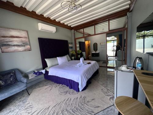 1 dormitorio con 1 cama con colcha blanca en Lawson’s Beach Resort en San Juan