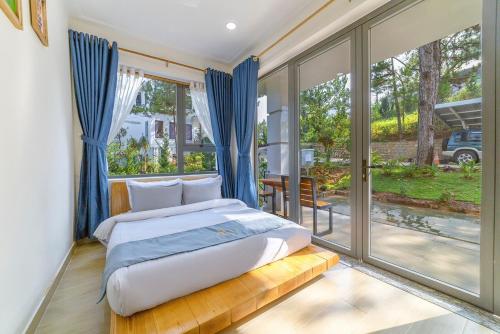 a bedroom with a bed and a large window at Love Hill Resort in Da Lat
