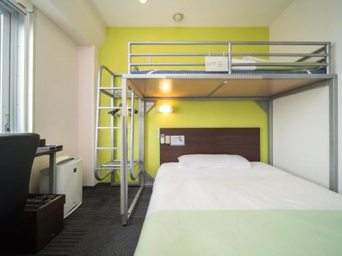 a bedroom with two bunk beds and a desk at Super Hotel Tozai line Ichikawa Myoden Ekimae in Ichikawa