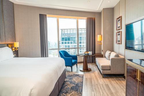 a hotel room with a bed and a living room at Centara Grand At CentralWorld in Bangkok