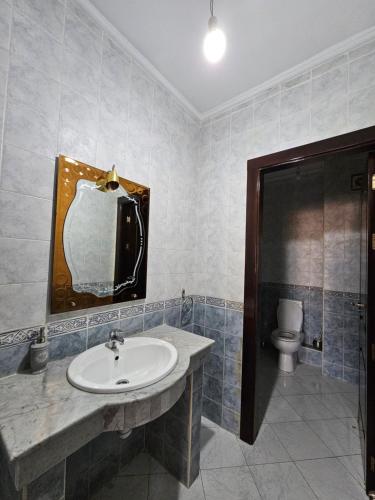 La salle de bains est pourvue d'un lavabo et de toilettes. dans l'établissement la perle du tanger R, à Tanger