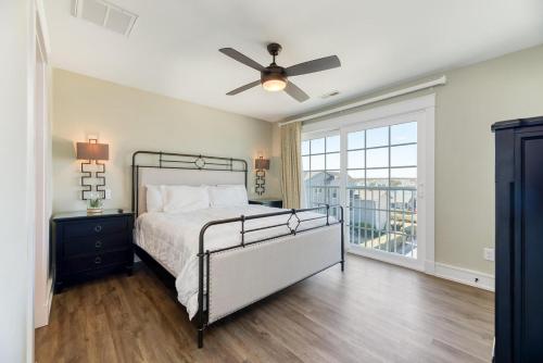 Un dormitorio con una cama y un ventilador de techo. en Dune it Wright at Carolina Shores, en Nags Head