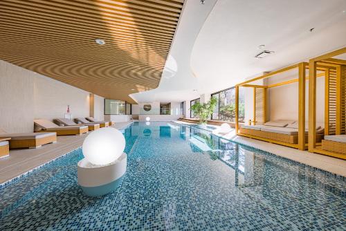 una piscina en una habitación de hotel con camas en nol hakone myojindai, en Hakone