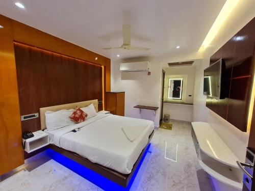 a bedroom with a large bed and a bath tub at Hotel Sannidhi in Vijayawāda