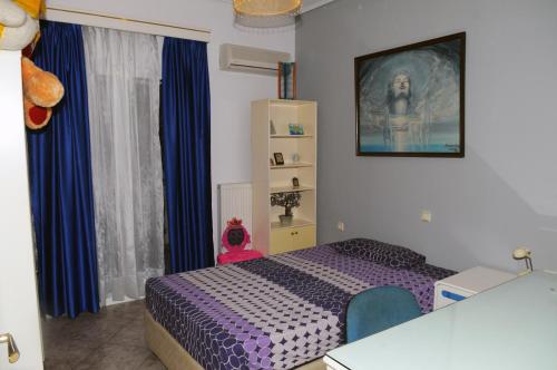 a bedroom with a purple bed and blue curtains at luxury villa samos in Vathý