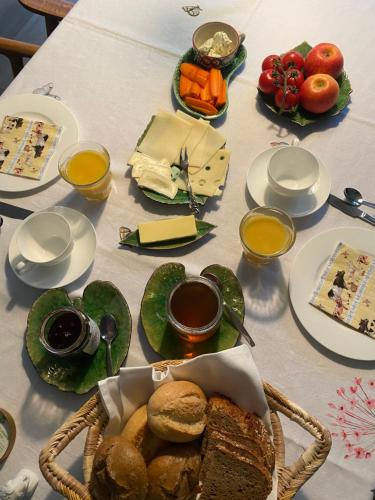 einen Tisch mit Teller mit Essen und Brot darauf in der Unterkunft Bed & Breakfast am Rheinsteig Bad Honnef in Bad Honnef am Rhein