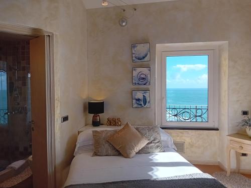 een slaapkamer met een bed en een raam met uitzicht op de oceaan bij Alla Porta Rossa in Manarola