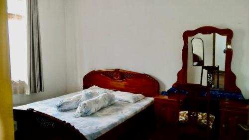 um quarto com uma cama com almofadas e um espelho em Sewa Rumah 4 Kamar Tidur em Bandung