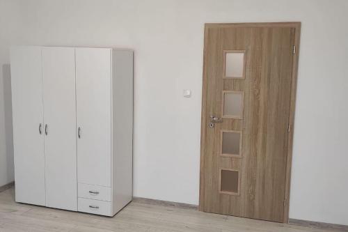 レビツェにあるNádherný byt v centre mestaの木製のドアとクローゼットが備わる客室です。