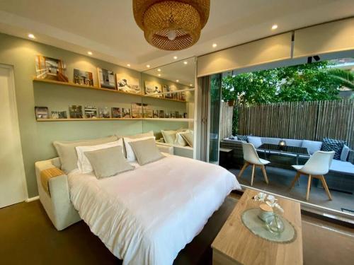 um quarto com uma grande cama branca e uma mesa em Beautiful 1 bedroom unit 1 block from Coogee beach em Sidney