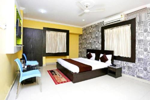 1 dormitorio con 1 cama y 1 silla azul en Hotel Sai Sandpiper Puri Near Sea Beach en Puri