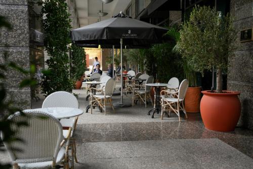 an outdoor seating area with tables and chairs and an umbrella at Ritz Carlton DIFC Downtown Dubai in Dubai
