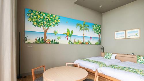 a room with two beds and a table at REF Okinawa Arena by VESSEL HOTELS in Okinawa City