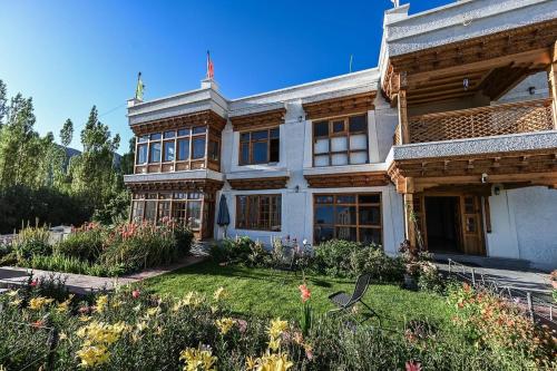 an old house with a garden in front of it at Namra Villa in Leh