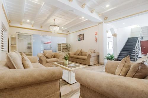 ein großes Wohnzimmer mit Sofas und einer Treppe in der Unterkunft Super Capital O Edassery Resort in Kattappana