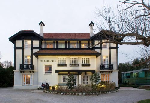 ein großes Haus mit einem schwarz-weißen Gebäude in der Unterkunft Las Carolinas Garden in Santander