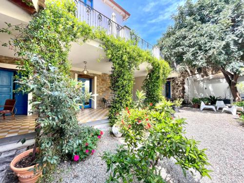 una casa con muchas plantas y flores en Il Carrubo & SPA, en Bari Sardo
