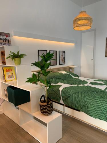 Un dormitorio con una cama verde y blanca y una planta en Luna y Sol, en Valencia