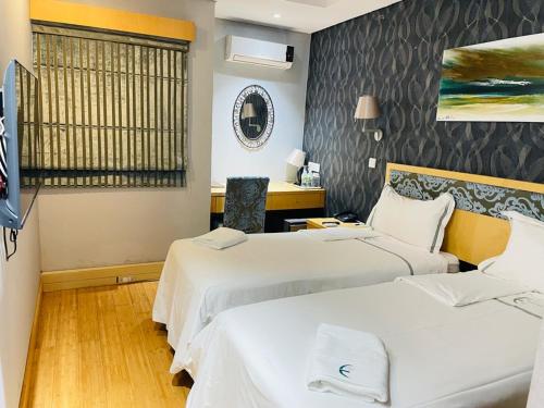 Habitación de hotel con 2 camas y TV en Aquarian Tide Hotel en Gaborone