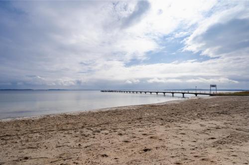 a pier stretches out into the water on a beach at App 14 Entspannen im Wellengang! in Dranske