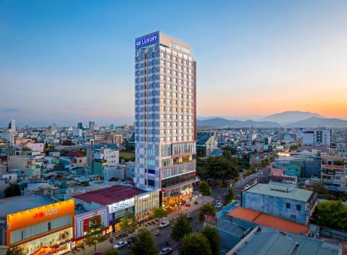 ein hohes Gebäude mitten in einer Stadt in der Unterkunft G8 Luxury Hotel and Spa Da Nang in Đà Nẵng