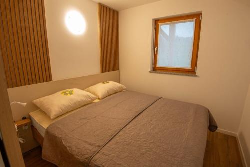 a small bedroom with a bed and a window at Vineyard Cottage Mayolka - Happy Rentals in Novo Mesto