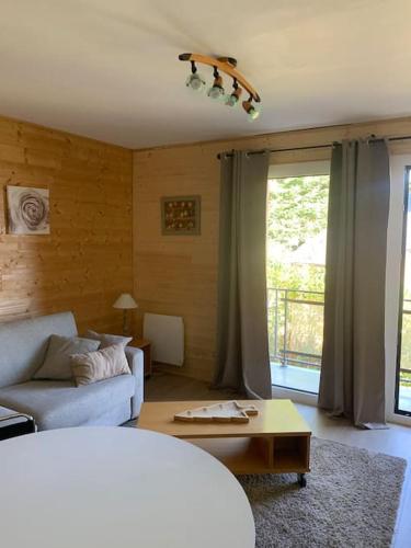 un salon avec un canapé et une table dans l'établissement A 5 minutes a pied du centre , Appartement T2 Font-Romeu, à Font-Romeu-Odeillo-Via
