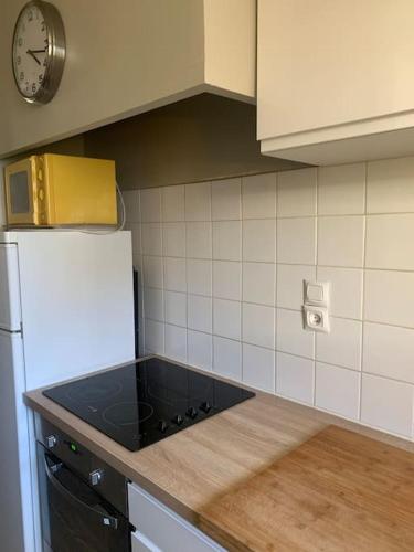 Il comprend une cuisine équipée d'une cuisinière. - un four supérieur à côté d'un réfrigérateur dans l'établissement A 5 minutes a pied du centre , Appartement T2 Font-Romeu, à Font-Romeu-Odeillo-Via