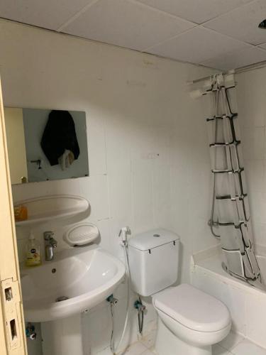 ein weißes Bad mit einem WC und einem Waschbecken in der Unterkunft The Hostel in Dubai