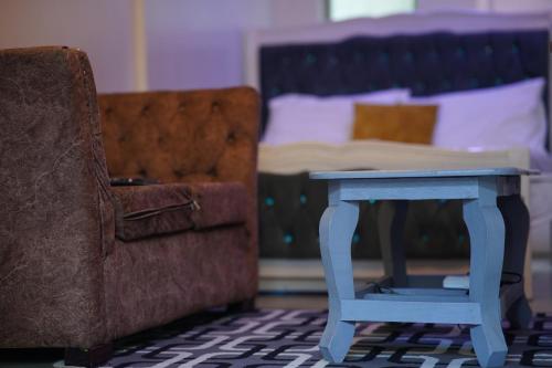 un lit avec une table bleue à côté d'une chaise dans l'établissement Serenity Retreat, à Nairobi
