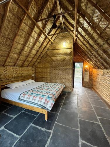 uma cama num quarto com tecto em madeira em Tropical Hampi em Hampi