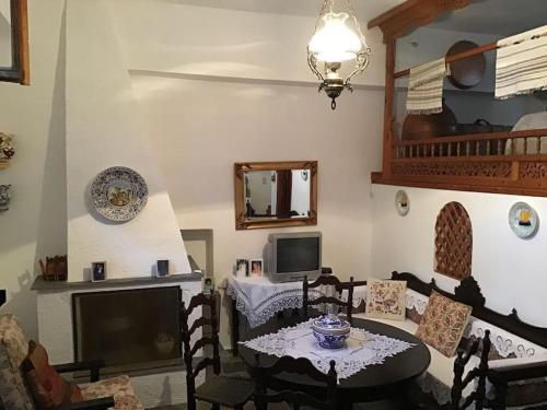 un soggiorno con un tavolo e una televisione di Θέτιδα House a Skiros
