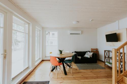 a living room with a table and chairs and a couch at LVM tūrisma un atpūtas centrs "Spāre" in Spāre