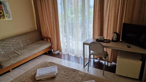 um quarto de hotel com uma cama, uma secretária e uma janela em Karakum hotel em Ureki